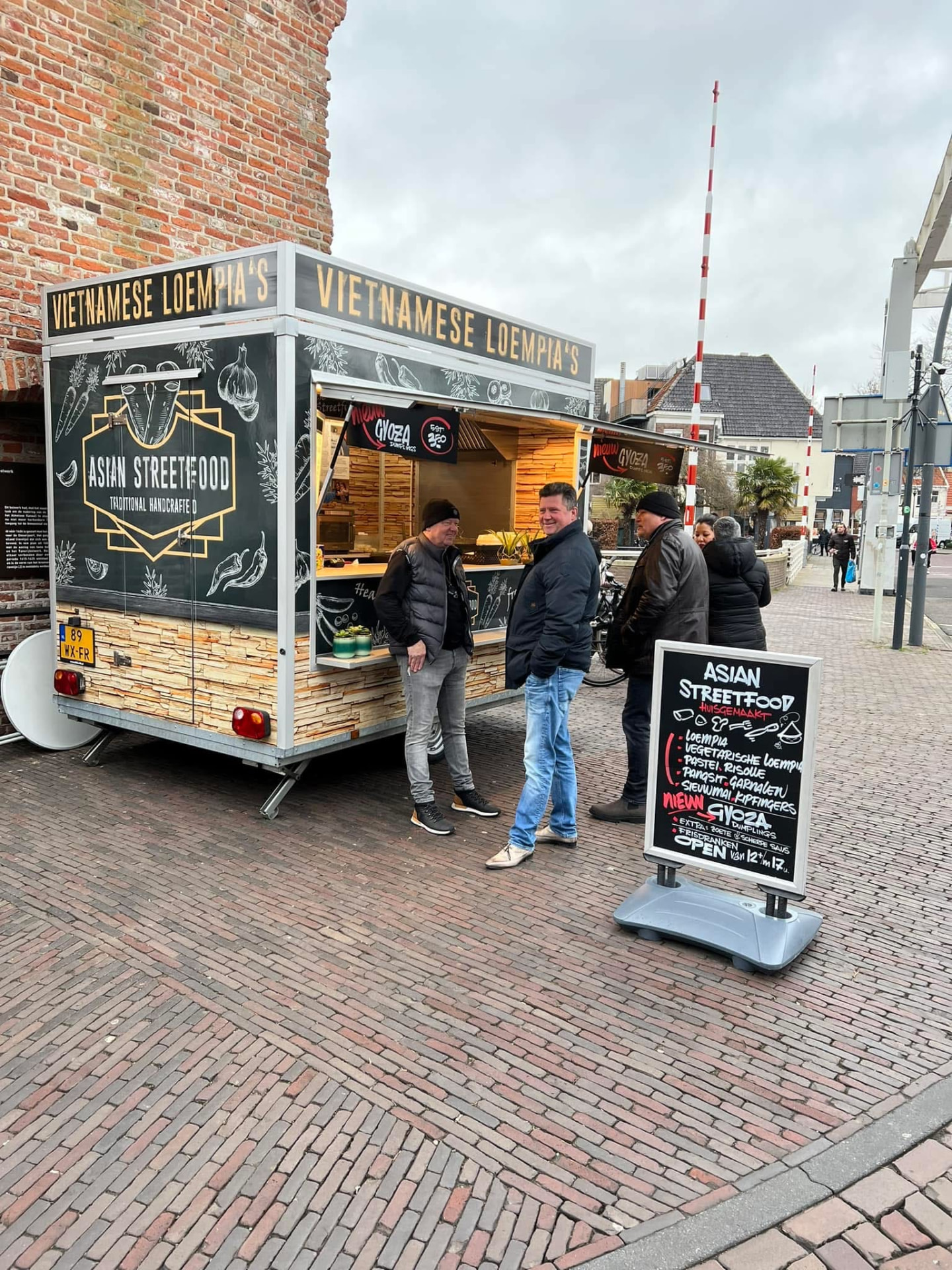 Klanten bij de kraam met het menubord